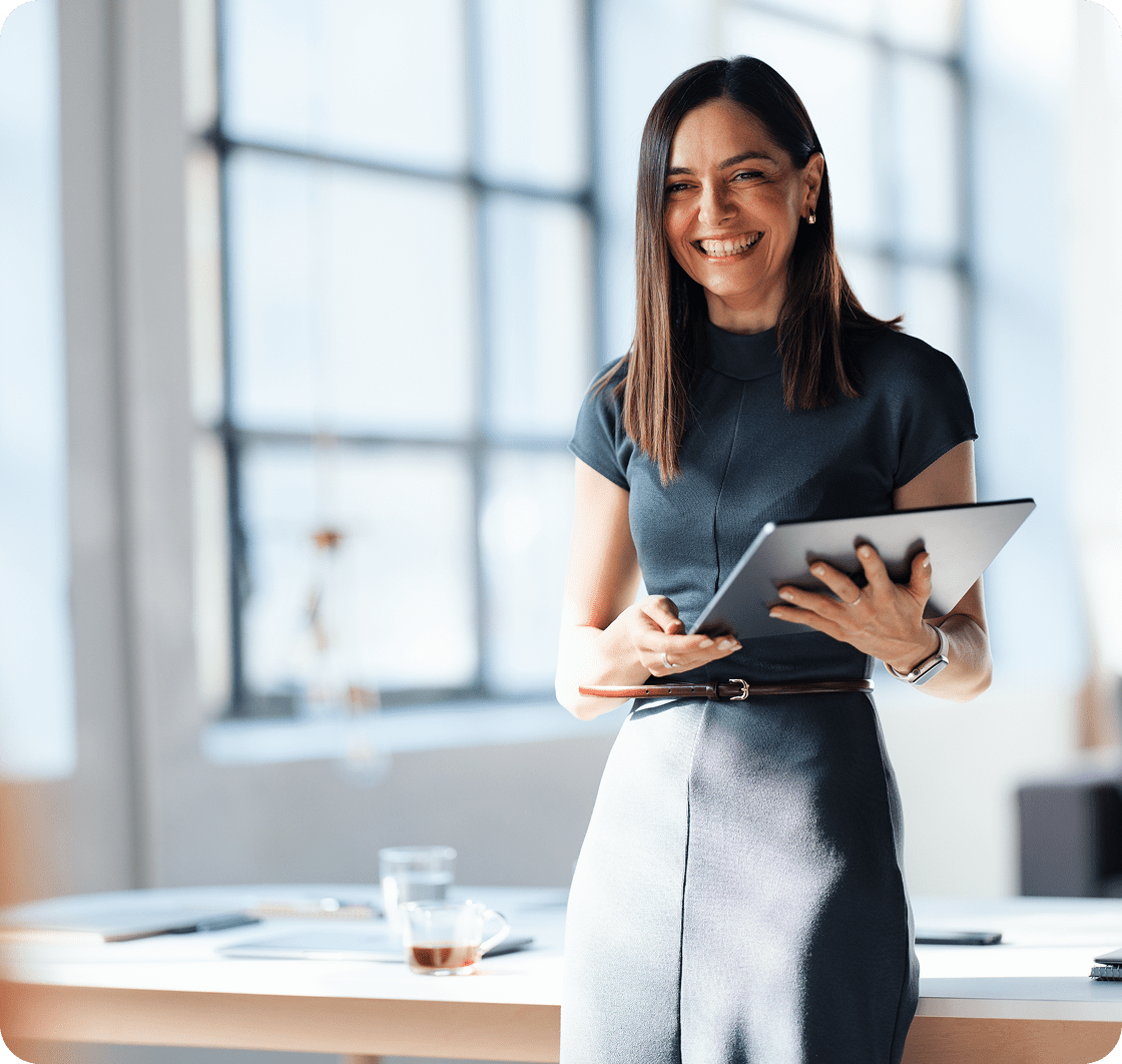 Confident woman standing with tablet indoors