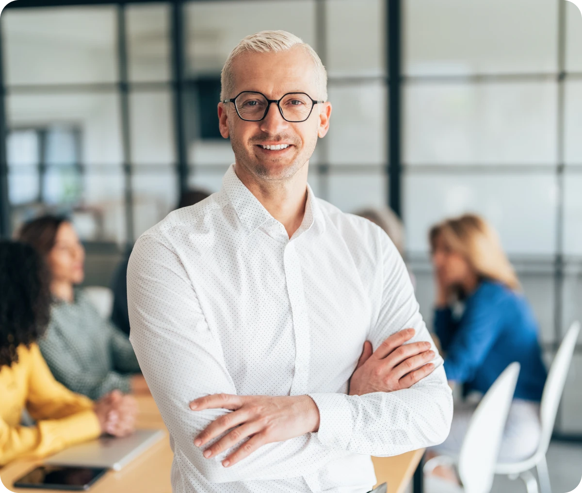 Confident man standing with colleagues behind